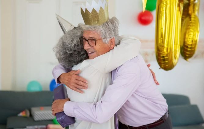 Senior couple hugging at birthday party