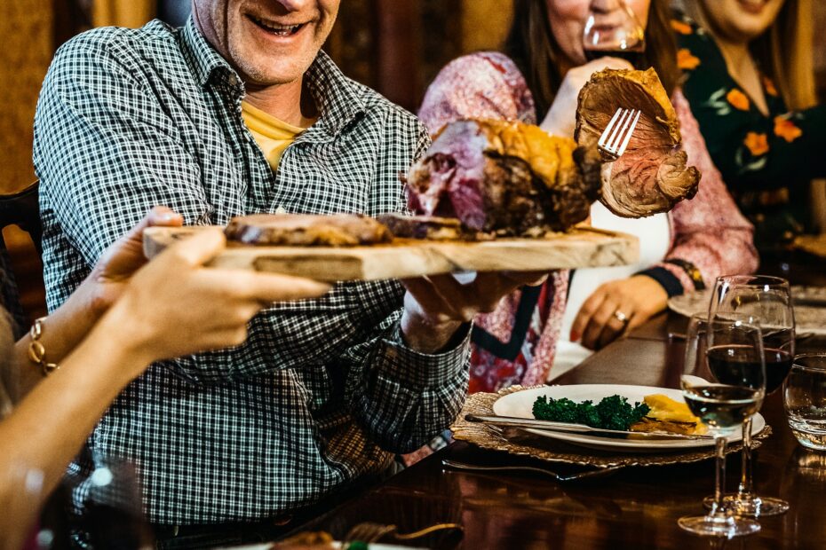 Family passing around meat platter at dinner