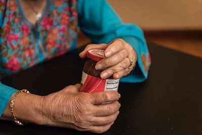 Older woman with weak hands opening jar