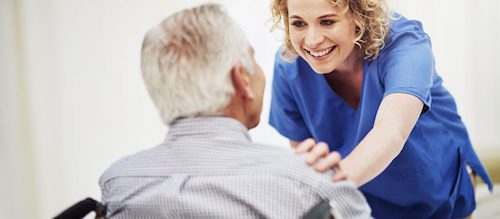 Caregiver talking with elderly male patient