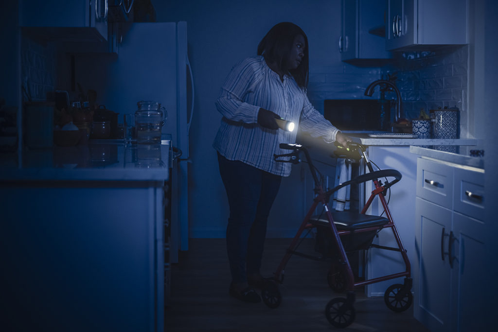 Woman with walker using flashlight during power outage