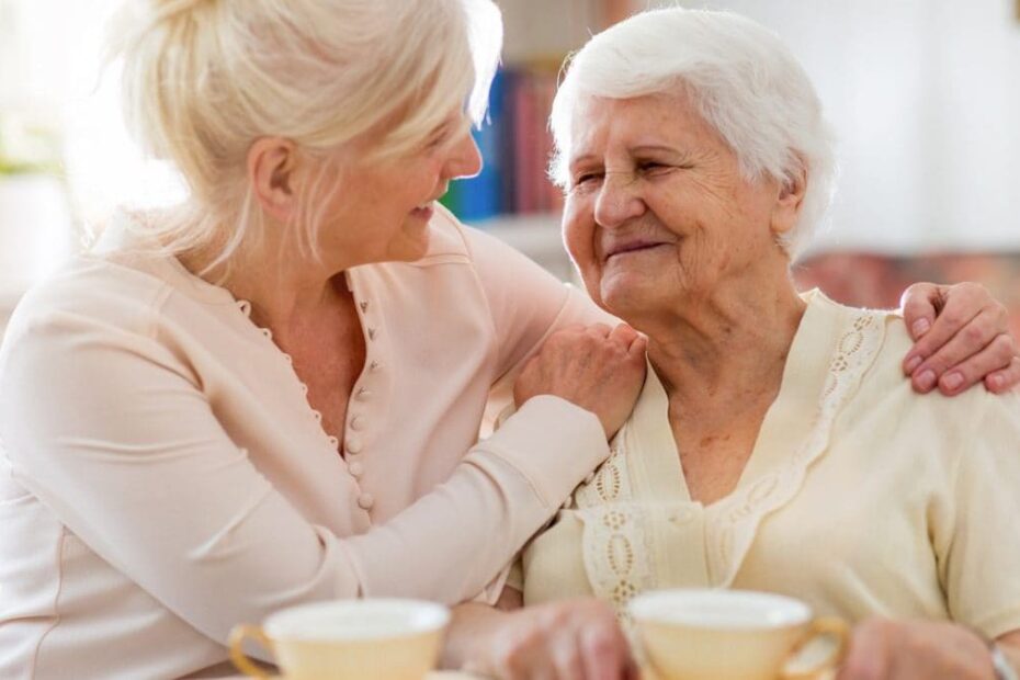 Elderly woman and woman caregiver smiling