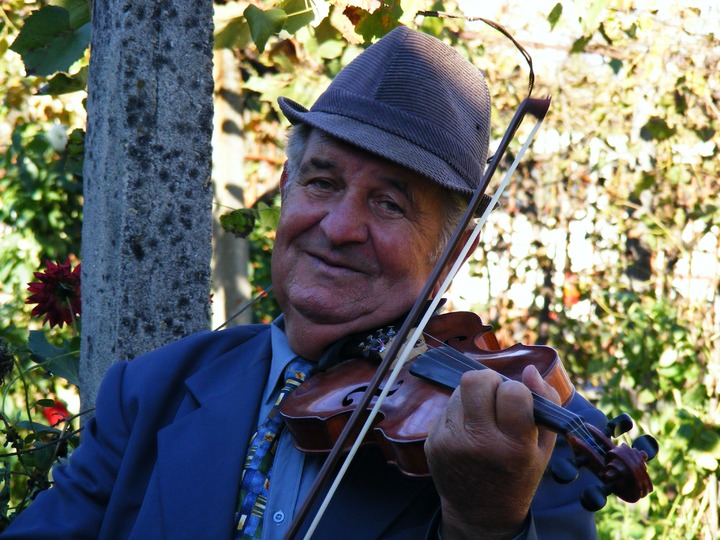 smiling man playing fiddle violin