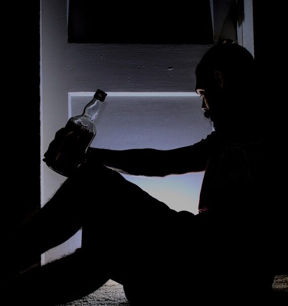 Man drinking alcohol in a dark room