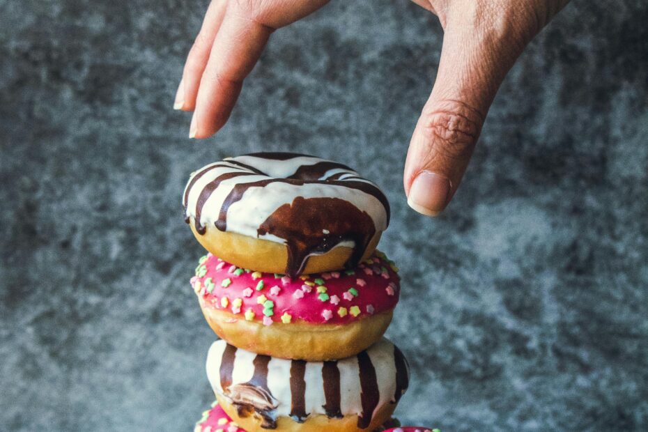 Hand reaching for a stack of donuts