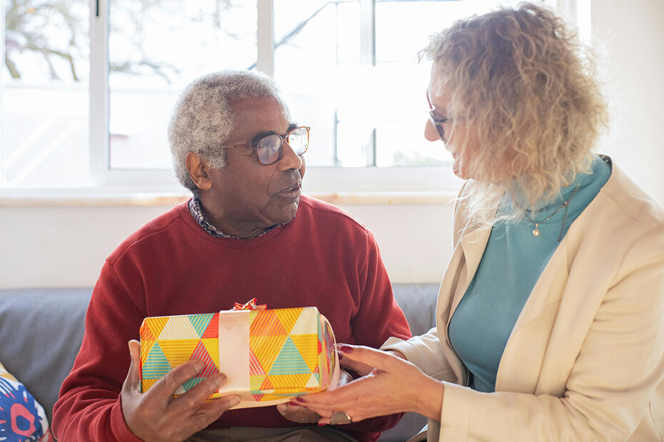Senior woman handing senior man a giftbox